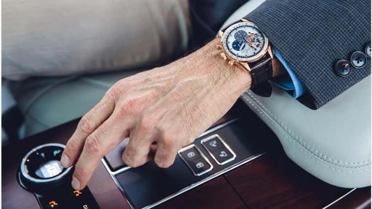 man's hand wearing a watch into a land rover vehicle