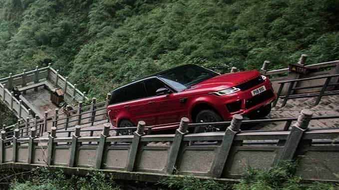 Range Rover Sport in red driving on stairs
