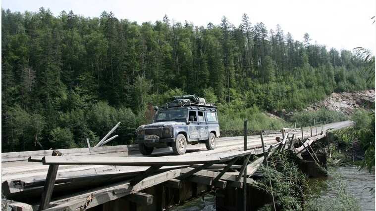 Land Rover Defender drives on a bridge