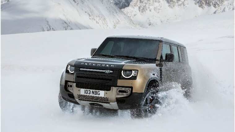 Land Rover Defender is driving in snow