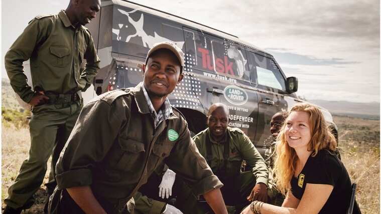 Tusk volunteers photo in front of a land rover