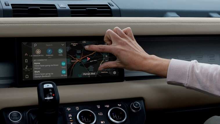 human is zooming in the navigation screen of a land rover vehicle