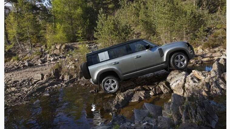 Land Rover Defender is driving into a river