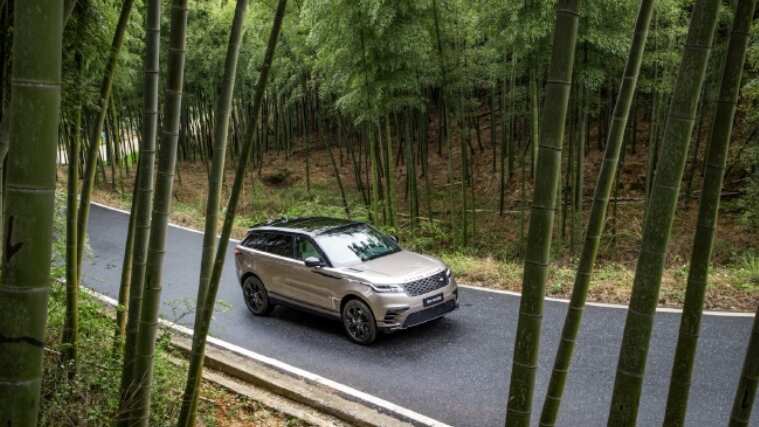 Land Rover vehicle is driving through forest route