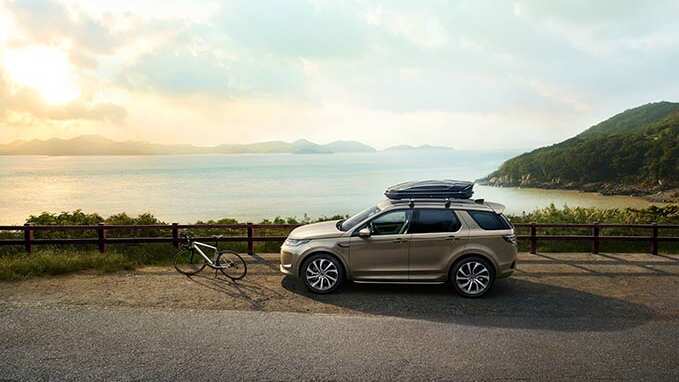 Land Rover Discovery parked next to the sea behind a bicycle