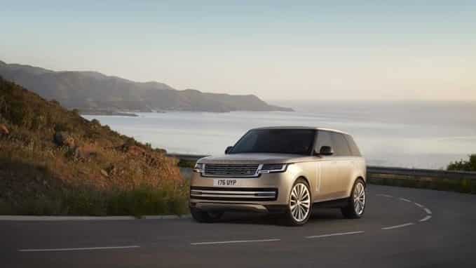New Range Rover driving on a road next to the sea