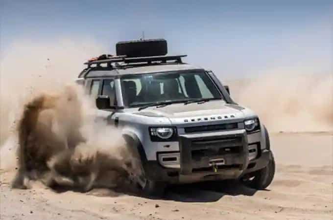 Land Rover Defender driving through desert