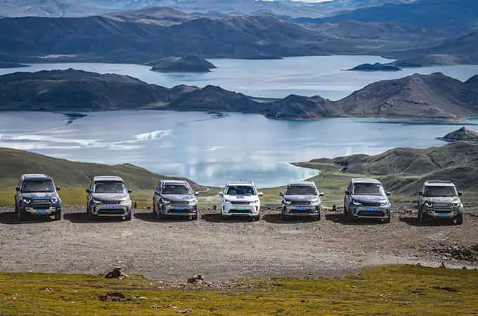 Land Rover vehicles parked in mountain landscape