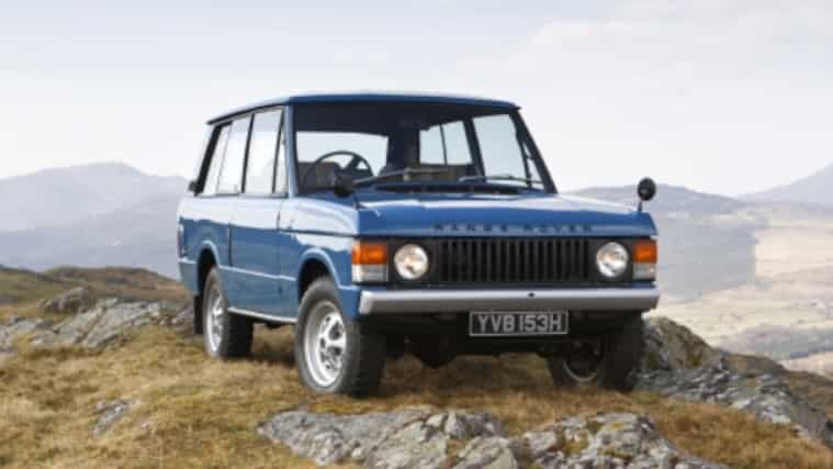 A blue Range Rover atop a rocky hill