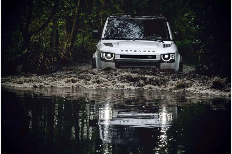 Range Rover Defender driving in a river