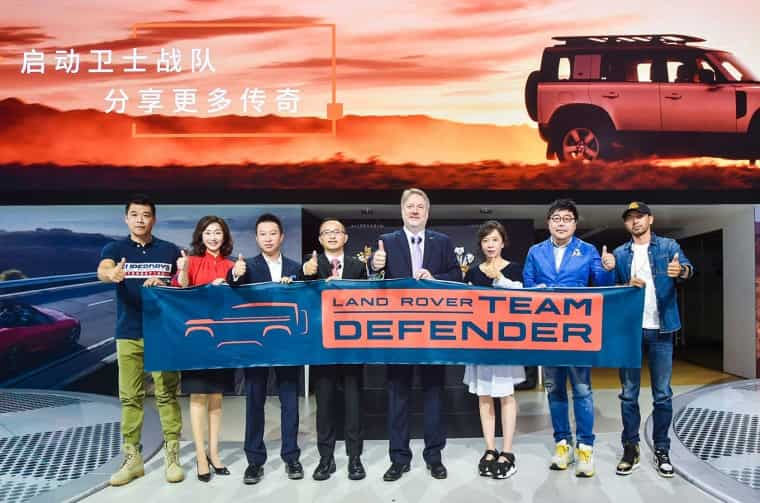 People holding Land Rover Team Defender banner