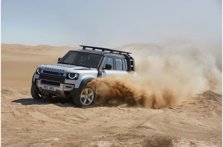 Land Rover Defender driving through desert