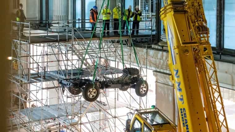 Land Rover Defender Works V8 chassis being lifted with crane