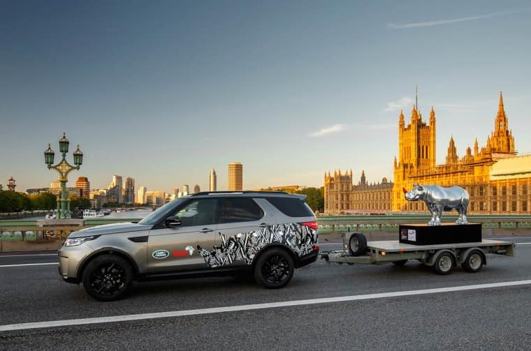 Land Rover Discovery pulling trailer with Land Rover Rhino sculpture