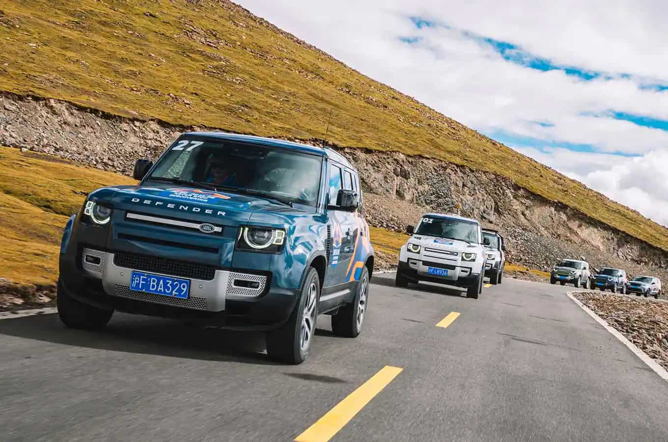 Land Rover Defender convoy driving on road