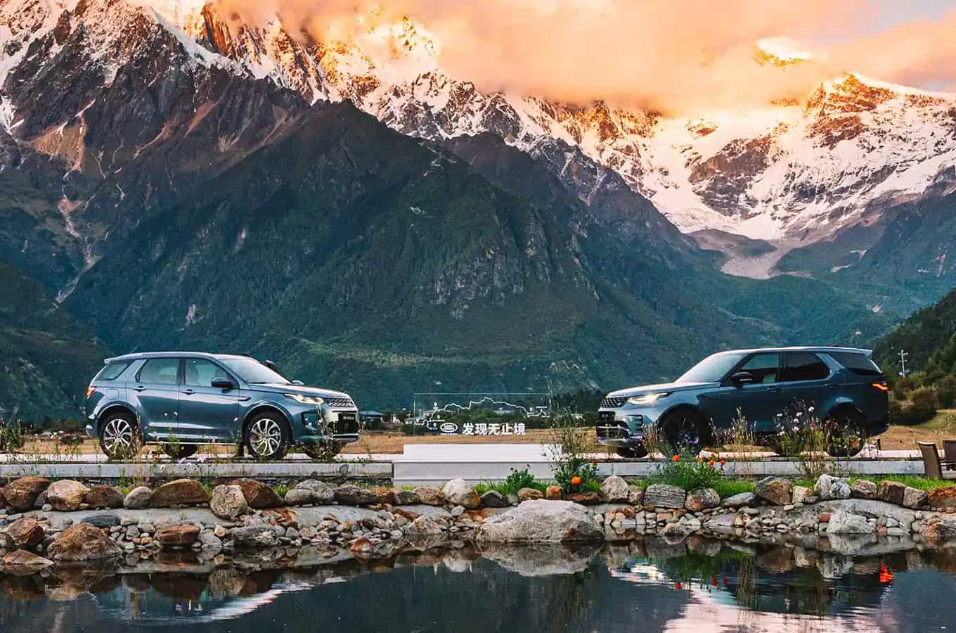 Land Rover Discovery vehicles parked in mountain landscape