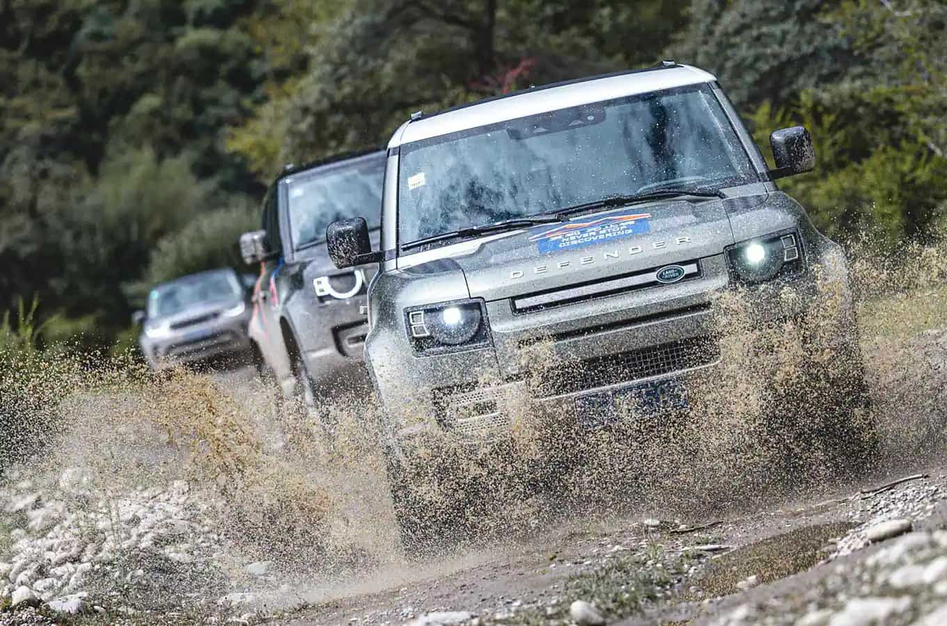 Land Rover Defender vehicles driving through water