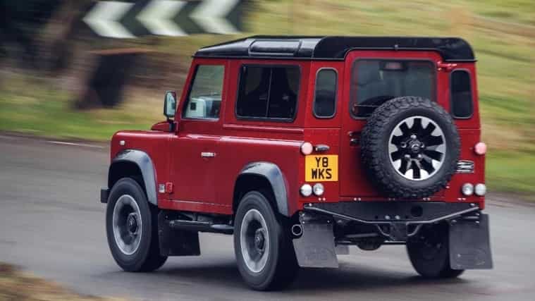 Rear view of the Land Rover Defender V8 driving down a road