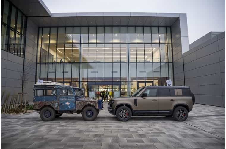 Land Rover Series I and Land Rover Defender 110 parked in front of building