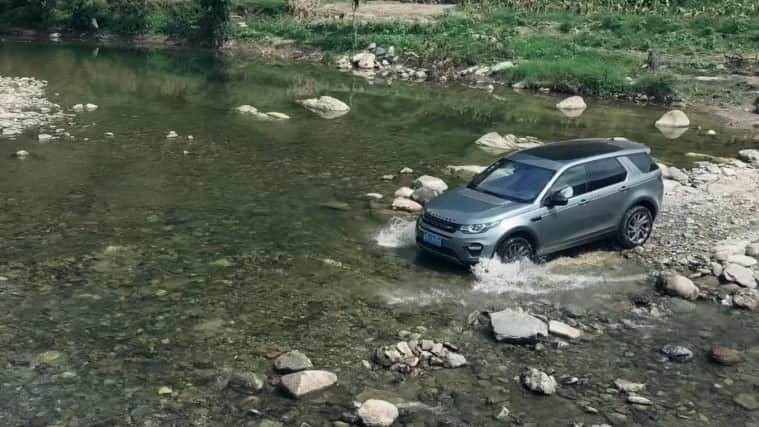A Discovery driving through a stream