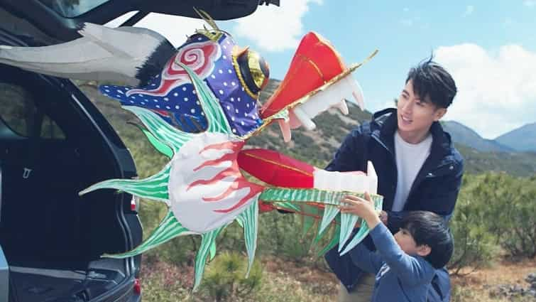 Person watches as child stores away his kite